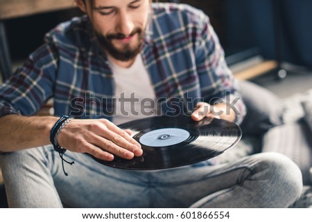 Similar – Image, Stock Photo Man holding vinyl record. Vintage music style. Rock style. Male wearing black jacket holding black disc standing on dark background. Retro music