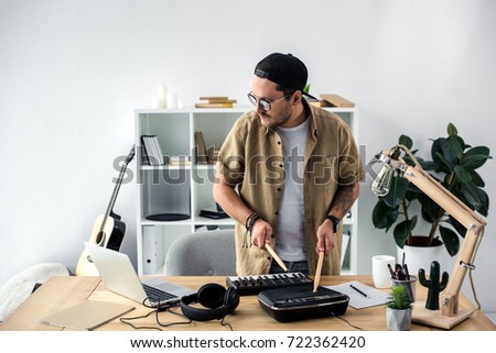 young sound producer playing on drum machine with drumsticks Zdjęcia stock © 