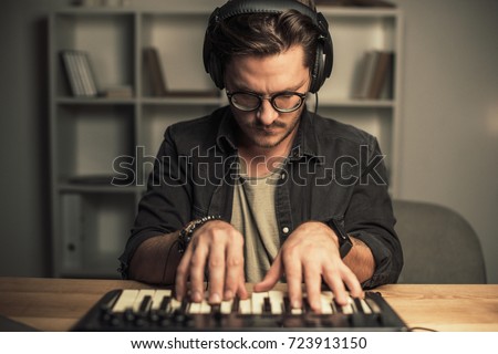 handsome young man with headphones working with keyboard controller Zdjęcia stock © 