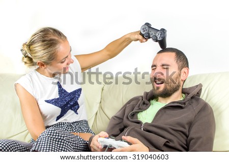 woman video games joking hits man head with joypad controller videogames