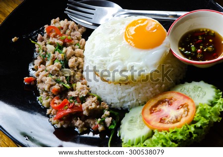 Rice with stir-fried chicken with basil leave and fried egg on top.