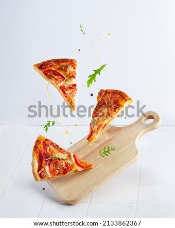 Levitating margherita pizza slices with flying arugula, butter and pepper Сток-фото © 