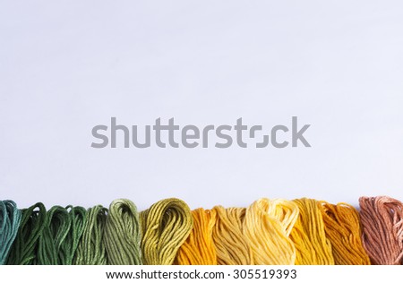 multicolored embroidery threads on white background for concepts of needlecrafts and domestic chores