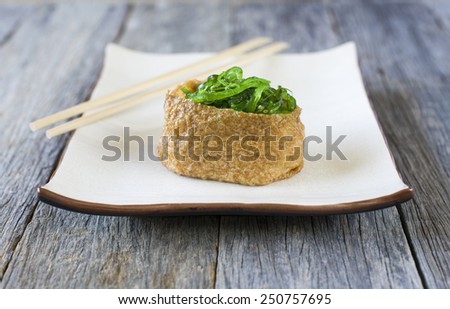 pouch of deep fried tofu filled with sushi rice and seaweeds, type of Japanese food
