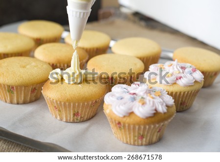 basic cupcakes baking with squeezing icing on the top