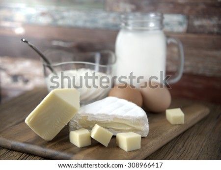 Dairy products with eggs, milk and tasmania double brie cheese on wooden board \
with selective focus