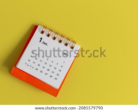 Desktop calendar for January 2022 on a yellow background.