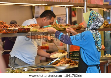 MALACCA, MALAYSIA - DECEMBER 24: Muslim lady preparing halal food on MARCH 24, 2014 in Malacca, Malaysia. Restaurants in Melaka are famous for asam pedas (spicy sour dishes).
