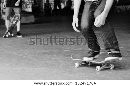 Young teen friends on skateboard in graffiti skate park