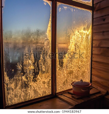 Winter dawn in frozen window. Frozen window winter sunrise