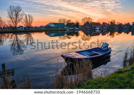Boat on lake water at dawn village scene. Village lake boat sunrise dawn. Sunrise village lake boat at dawn landscape