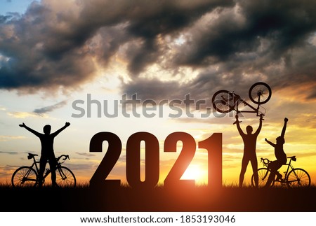 Silhouette of cyclists with bicycles at sunset. Forward to the New Year 2021. Holiday concept.