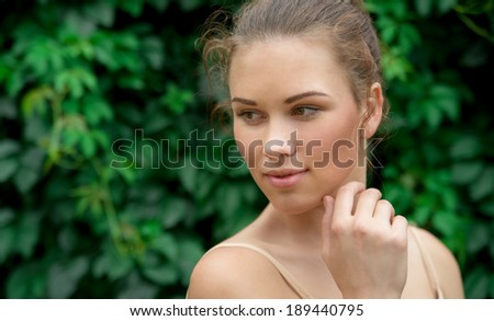 Beautiful young adult woman with clean fresh skin  on green background, pure beauty, natural beauty
