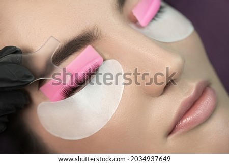 Master glues eyelashes to lash roller by applicator. Eyelash Care Treatment: eyelash lifting and curling, lash lamination and extension. Сток-фото © 