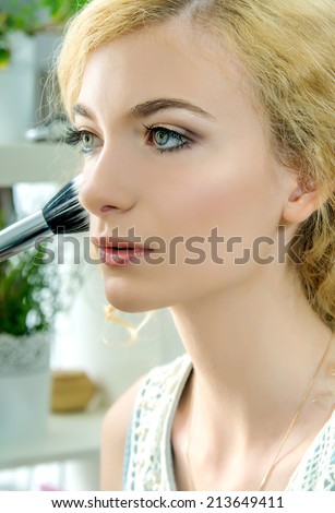 Make up. Cosmetic. Make-up artist applying foundation powder or blush with makeup brush on model\'s cheek. Base for Perfect Make-up.Applying Make-up.