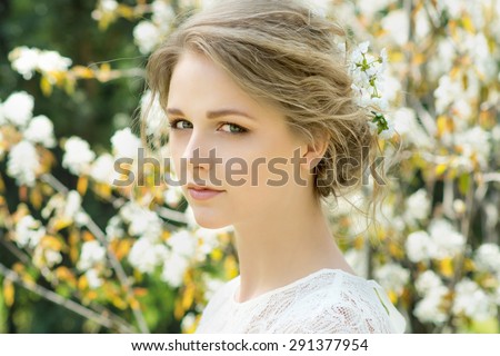 Portrait of beautiful young woman with flowers in hair. Make up and hair style. Wedding bride make up.