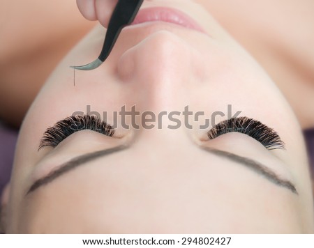 Eyelash Extension Procedure.  Woman Eye with Long Eyelashes. Lashes. Close up, selected focus.