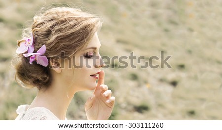 Portrait of beautiful young woman with flowers in hair. Make up and hair style. Wedding bride make up.