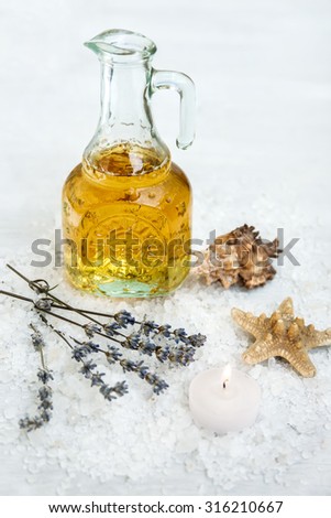 Spa and wellness setting with sea salt, oil essence, jasmin flowers and towels on wooden background.  Relax and treatment therapy. space for text.  Selective focus. Close up.