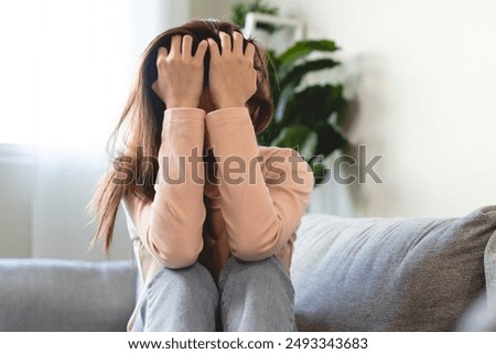 Depression in teenage concept, Young women covering her face feeling anxious and unhappy lock themselves at home sad emotional alone, and have mental disorders.