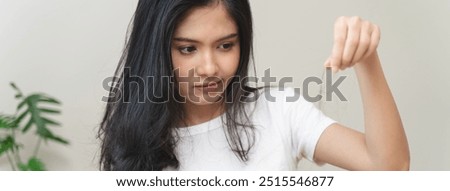 Similar – Image, Stock Photo Long-haired brunette Asian woman dressed in a white sweater, looking in the mirror and combing her hair