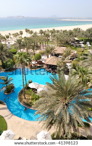 Swimming pool at hotel recreation area, beach and view on Jumeirah Plam man-made island, Dubai, United Arab Emirates
