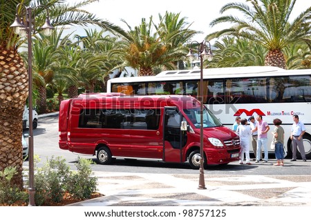 CRETE ISLAND, GREECE - MAY 13: The modern bus for tourists transportation and group of tourists are near hotel on May 13, 2010 in Crete, Greece.  15000000 tourists have visited Greece in year 2010