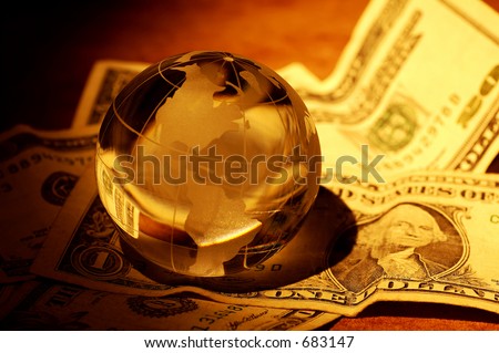 Glass Globe on Money With Creative Lighting.  Global Finance Concept