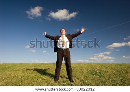 Freedom - Happy business man standing on green grass - arms outstretched