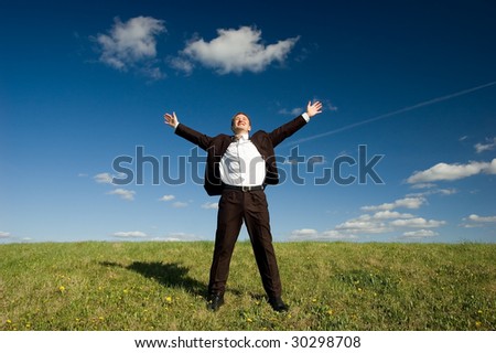 Freedom - Happy business man standing on green grass - arms outstretched