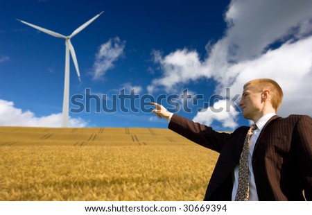 Businessman showing to the future green energy - wind energy conception