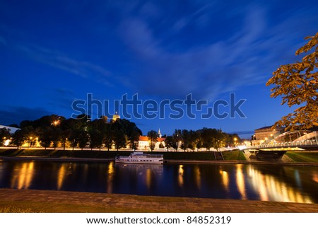 Vilnius city at night - river Neris, Mindaugas bridge, Gediminas tower and old town in front. Lithuania.