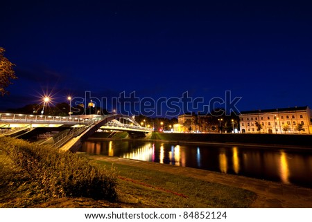 Vilnius city at night - river Neris, Mindaugas bridge, Gediminas tower and old town in front. Lithuania.