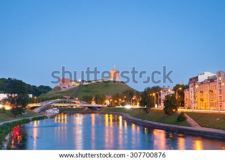 Vilnius city at night - river Neris, Mindaugas bridge, Gediminas tower and old town in front. Vilnius is known for its Old Town of beautiful architecture, declared a UNESCO World Heritage Site.