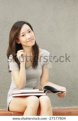 Happy Asian Chinese Female Student With Gray Wall