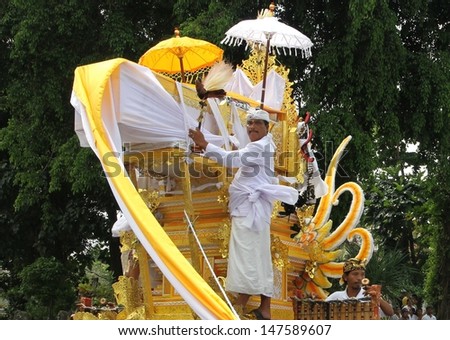 DENPASAR, INDONESIA - MAY 12:  A Balinese Holy man rides the funeral pyre scaring away evil spirits in a Ngaben or cremation ceremony in Ubud, Denpasar, Bali, Indonesia on May 12, 2013.