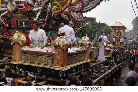 DENPASAR, INDONESIA - MAY 13: Holy men riding the funeral pyre in a street procession to a Royal Ngaben or cremation ceremony in Ubud, Denpasar, Bali, Indonesia on May 13, 2013.