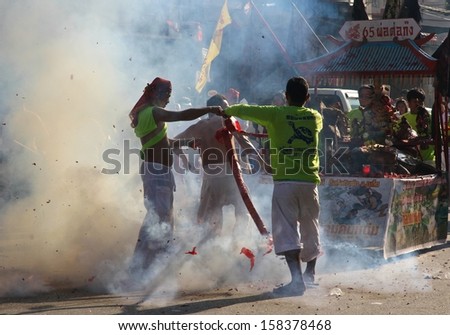 PHUKET, THAILAND - OCTOBER 11: A traditional scene of fireworks being set off during the street parade for the Phuket Vegetarian Festival, Phuket Town, Phuket, Thailand on the 11th October, 2013.