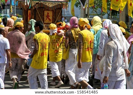 PHUKET, THAILAND - OCTOBER 12: A traditional scene of Thai devotees with fireworks in the street procession of the Phuket Vegetarian Festival in Phuket Town, Phuket, Thailand on 12th October, 2013.