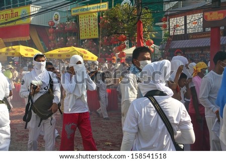 PHUKET, THAILAND - OCTOBER 12: A traditional scene of Thai devotees with fireworks in the street procession of the Phuket Vegetarian Festival in Phuket Town, Phuket, Thailand on 12th October, 2013.
