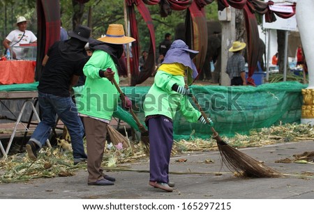 SURIN, THAILAND - NOVEMBER 15th: Workers cleaning up the street after breakfast for the elephants at the annual Elephant Roundup Festival in Surin, Thailand on the 15th November, 2013.