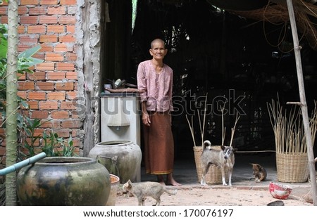 SIEM REAP, CAMBODIA - NOVEMBER 24: An elderly Cambodian woman with shaved head in preparation for entering a monastery outside her home in the countryside of Siem Reap, Cambodia on 24 November, 2013.