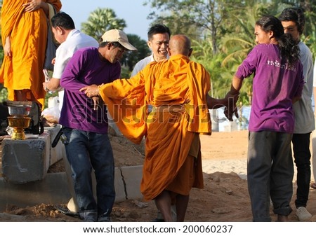 PHUKET, THAILAND - MARCH 24: A monk being helped out of the hole for the foundations of a building at a ground breaking ceremony held in Phuket, Thailand on the 24th March, 2014.