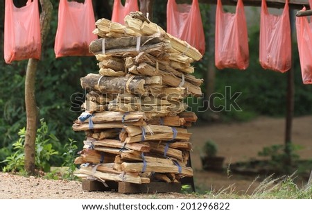 A neatly stacked pile of fire wood sitting on the side of the main road for sale near Dambulla, Sri Lanka.