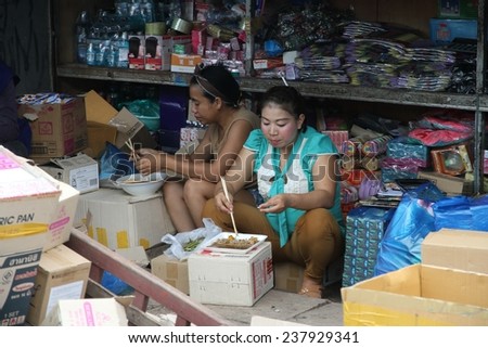 VIENTIANE, LAOS - AUGUST 6: Local women in a stall eating at the market of Vientiane, Laos on the 6th August, 2014.