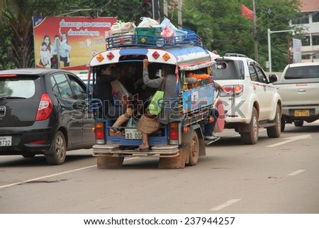 VIENTIANE, LAOS - AUGUST 6: An overloaded and crowded songthaew on the main road in the town of Vientiane, Laos on the 6th August, 2014.
