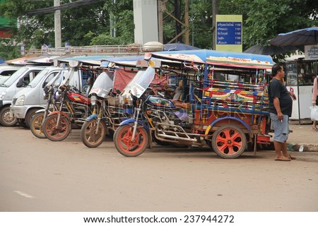 VIENTIANE, LAOS - AUGUST 6: A group of tuk tuks or songthaews parked on the side of the main road in the town of Vientiane, Laos on the 6th August, 2014.
