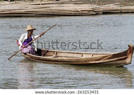 MANDALAY, MYANMAR - NOVEMBER 7:\
A local Burmese from the shanty town in a traditional wooden canoe on the Irrawaddy River near the  town of Mandalay, Myanmar on the 7th November 2012.