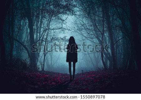 Ghost on the scary road in the paranormal world. Horrible dream. Strange forest in a fog. Mystical atmosphere. Dark wood. Mysterious road. Gothic witch. Background wallpaper. Gloomy times. 