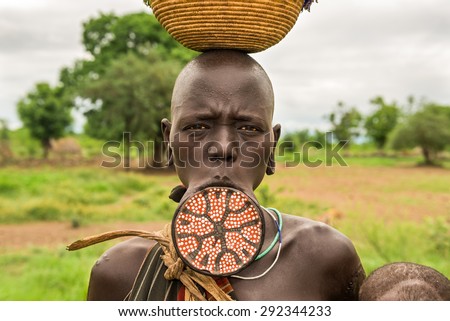 OMO VALLEY, ETHIOPIA - MAY 7, 2015 : Woman from the african tribe Mursi with a big lip plate poses for a portrait
